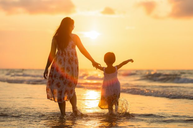 Sonnenuntergang am Strand mit dem Kind am Strand 